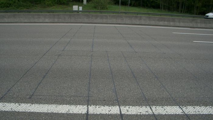 Orthogonal zur Fahrtrichtung verlaufende Linien auf einer Fahrbahn deuten auf darunterliegende Zählstellen hin.